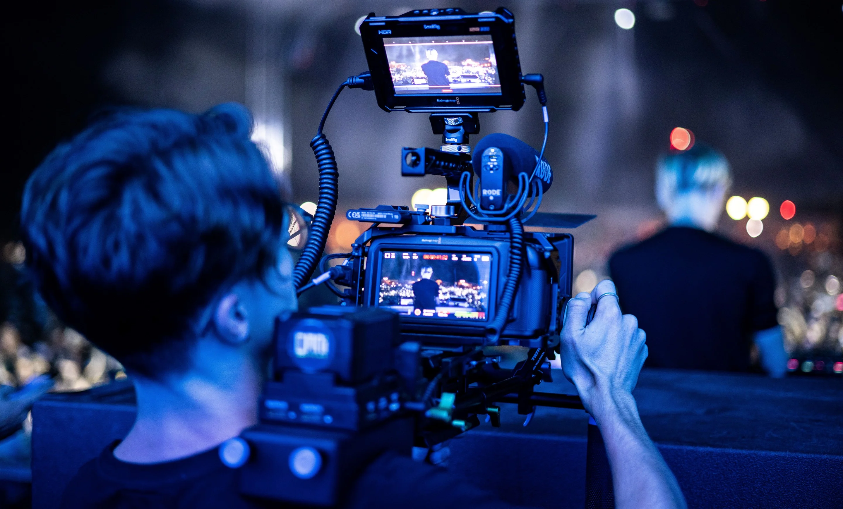 Cadreur Multiviews filmant un concert, moniteur de contrôle allumé