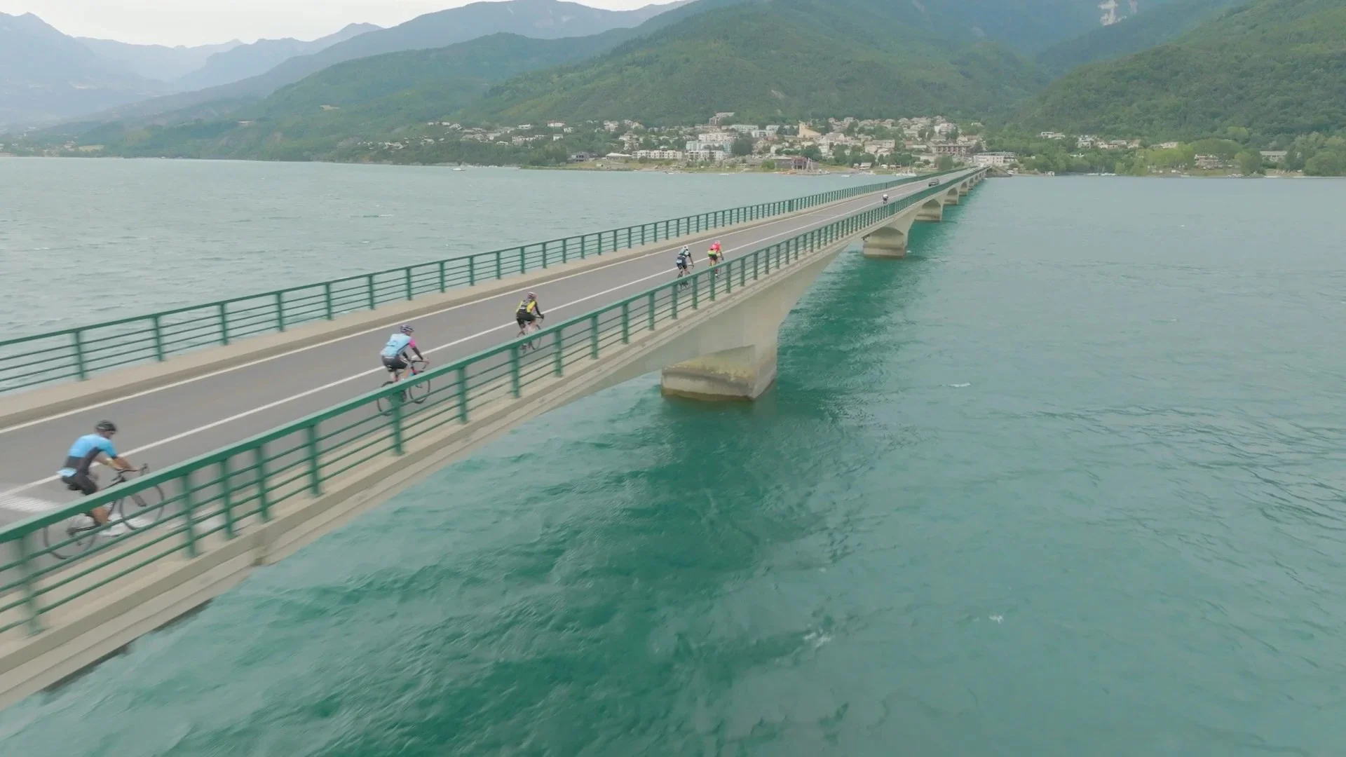 Cyclistes de l'Embrunman sur le pont du lac de Serre-Ponçon, vus du drone