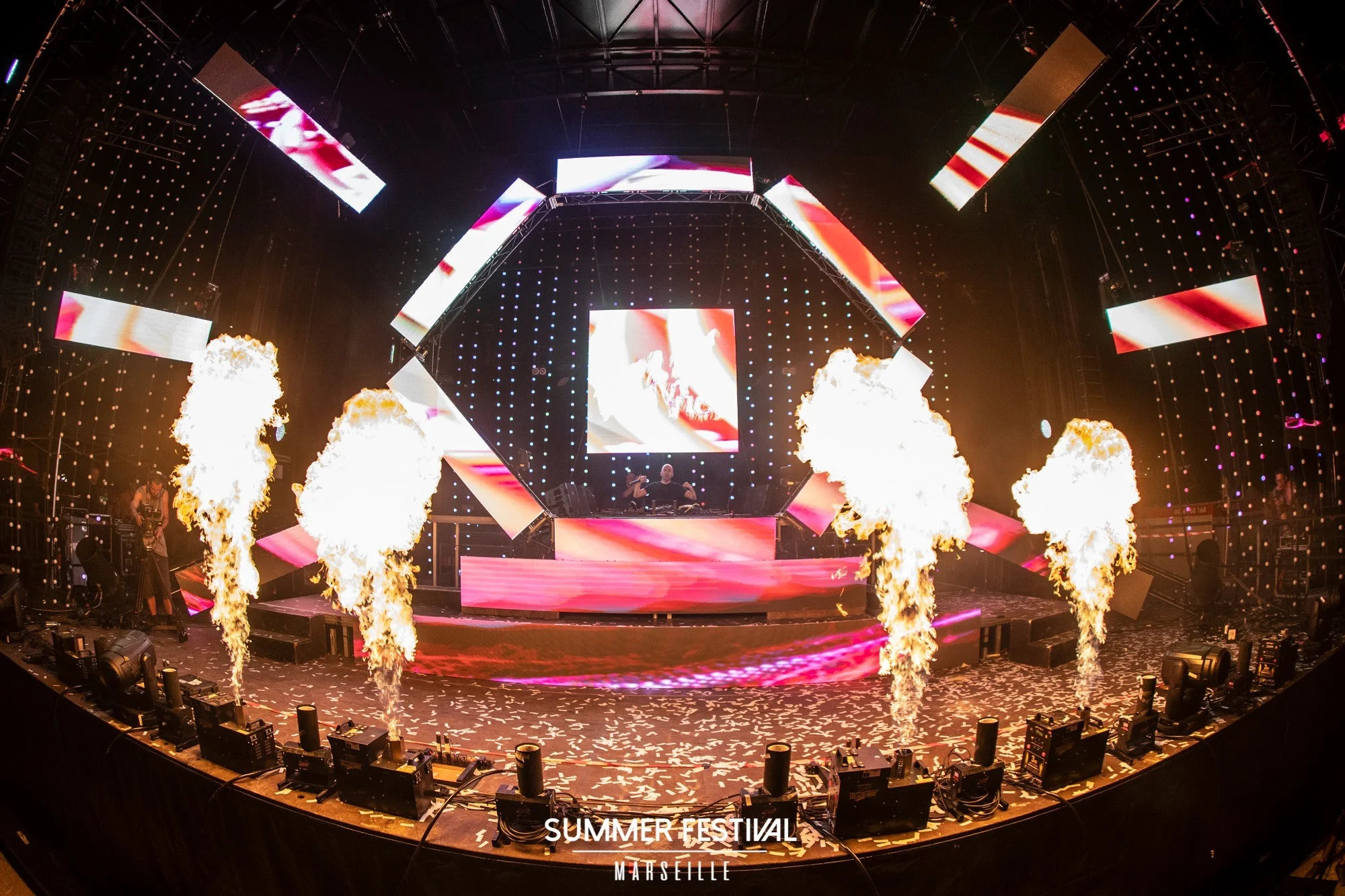 Scène du Summer Festival avec flammes et écrans pendant un show